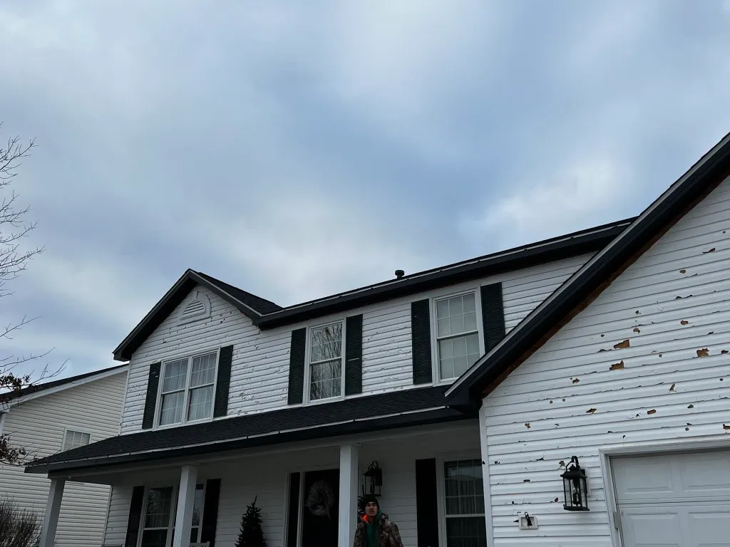 Hail impact divots on white vinyl siding — typical exterior collateral damage from a hail event