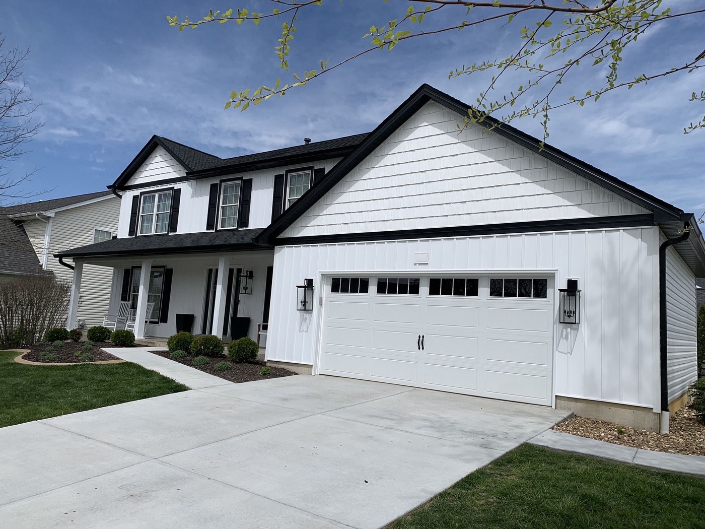 Roof Bros Restoration board-and-batten siding install on a white two-story home