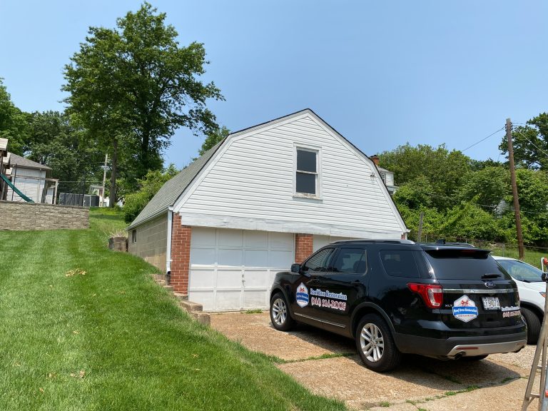 roof bros restoration branded truck 003 - Roof Bros Restoration - roofing gallery wisconsin illinois A white gambrel-roofed garage building with a black Roof Bros Restoration SUV with door magnets parked in front on a sunny...