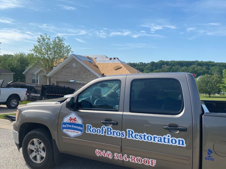 roof bros restoration branded truck 006 - Roof Bros Restoration - roofing gallery wisconsin illinois A tan Roof Bros Restoration branded pickup truck with logo and '(844) 314-ROOF' door graphics parked in front of a house w...