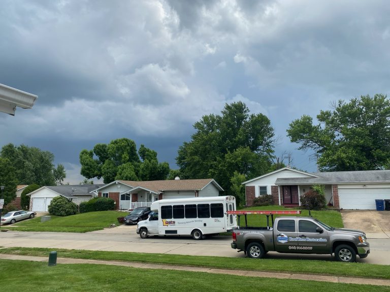 roof bros restoration branded truck 009 - Roof Bros Restoration - roofing gallery wisconsin illinois A Roof Bros Restoration branded pickup truck and a white shuttle bus parked on a residential street under a partly cloudy...