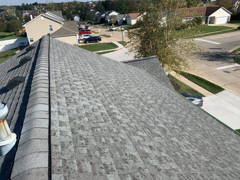roof bros restoration completed roof 001 2 - Roof Bros Restoration - roofing gallery wisconsin illinois An elevated view down the ridge of a newly shingled residential roof with gray architectural shingles, looking out over a...