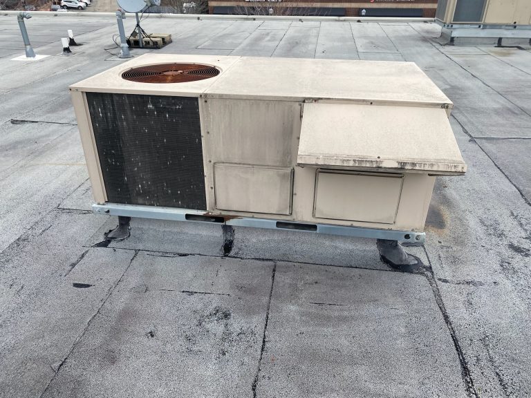 roof bros restoration illinois commercial flat roof 004 2 - Roof Bros Restoration - roofing gallery wisconsin illinois A tan rooftop HVAC condenser unit on a flat commercial roof with patched and weathered membrane areas around its base