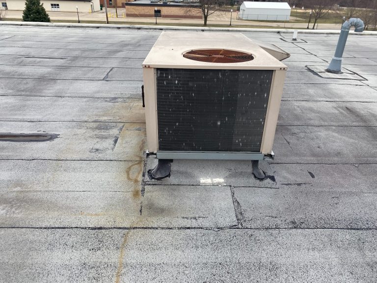 roof bros restoration illinois commercial roof leak 002 2 - Roof Bros Restoration - roofing gallery wisconsin illinois A rooftop HVAC condenser unit on a flat commercial roof showing damaged and patched membrane with visible staining at the...