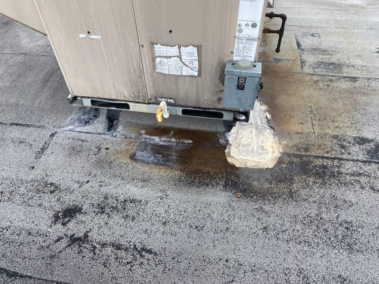 roof bros restoration illinois commercial roof leak 006 2 - Roof Bros Restoration - roofing gallery wisconsin illinois A close-up of an HVAC unit base on a flat commercial roof showing an electrical disconnect, drain pipe, and white insulati...