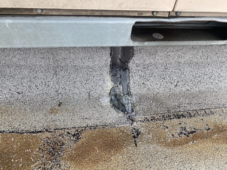 roof bros restoration illinois commercial roof leak 010 - Roof Bros Restoration - roofing gallery wisconsin illinois A close-up of a flat roof membrane showing a vertical seam with black sealant repair and visible cracking or damage in the...