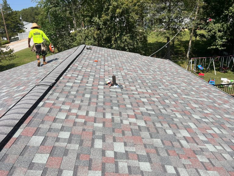 roof bros restoration illinois completed roof 004 - Roof Bros Restoration - roofing gallery wisconsin illinois A worker in a yellow safety shirt walks along the ridge of a newly installed multi-tone gray and red shingle roof