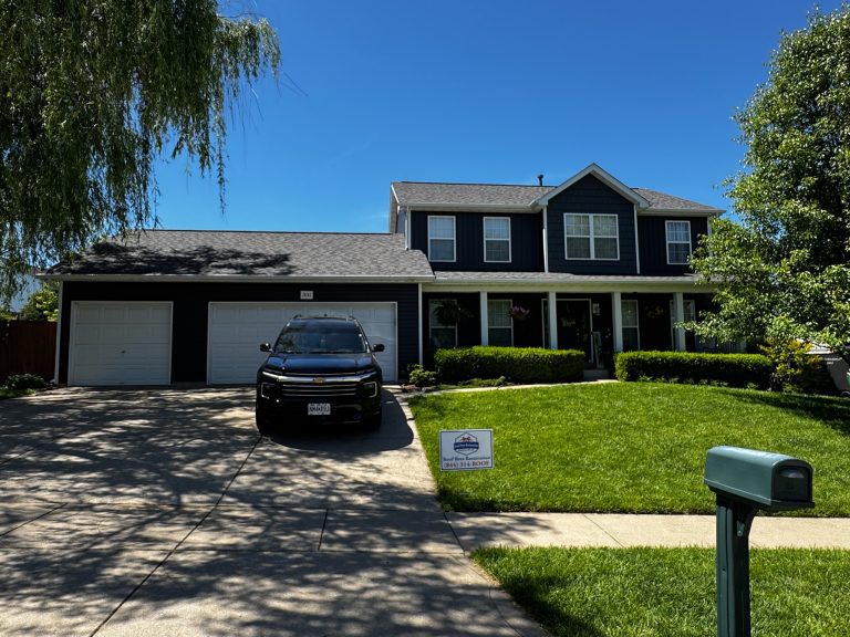 roof bros restoration illinois completed roof 009 - Roof Bros Restoration - roofing gallery wisconsin illinois A two-story home with dark navy siding, a covered front porch, and a two-car garage has a Roof Bros Restoration yard sign...