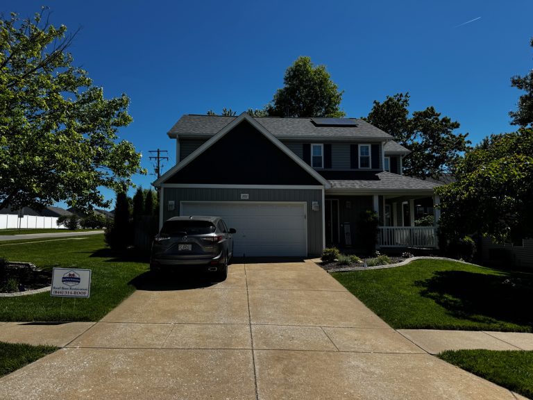 roof bros restoration illinois completed roof 015 - Roof Bros Restoration - roofing gallery wisconsin illinois Two-story residential home with dark gray siding, two-car attached garage, dark SUV in the driveway, and a Roof Bros Resto...