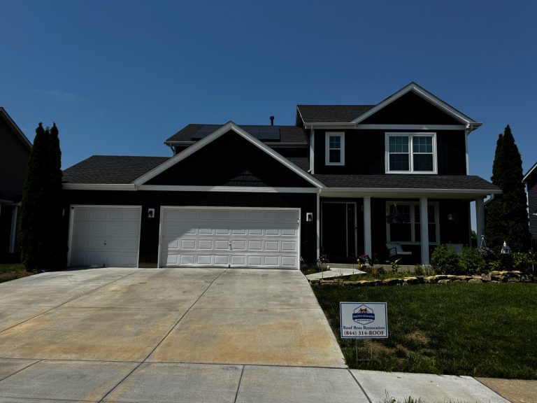 roof bros restoration illinois completed roof 018 - Roof Bros Restoration - roofing gallery wisconsin illinois Two-story residential home with dark blue siding, board-and-batten gable accent, dark shingle roof with solar panels visib...