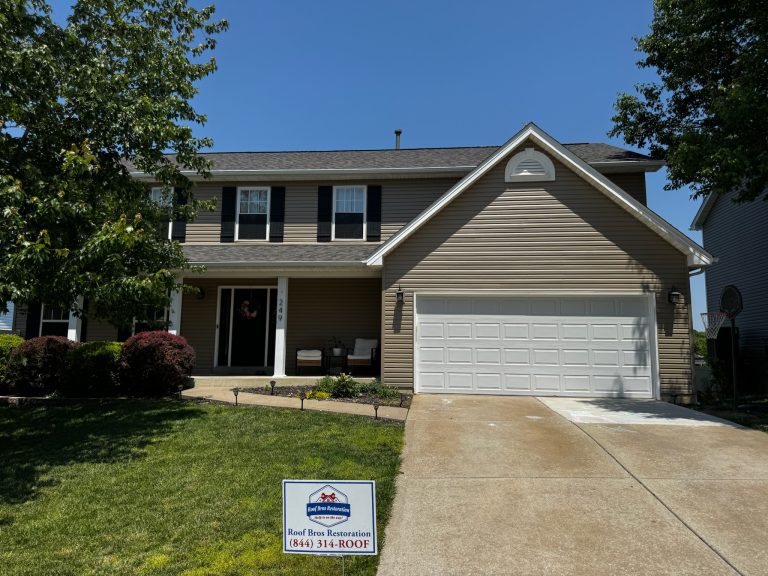 roof bros restoration illinois completed roof 021 - Roof Bros Restoration - roofing gallery wisconsin illinois Two-story residential home with tan siding, black shutters, two-car attached garage, covered front entry with seating, and...