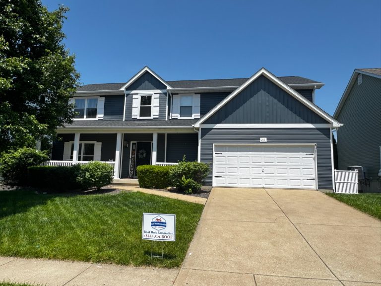 roof bros restoration illinois completed roof 022 - Roof Bros Restoration - roofing gallery wisconsin illinois Two-story residential home with gray and dark blue siding, covered front porch, two-car attached garage, dark shingle roof...