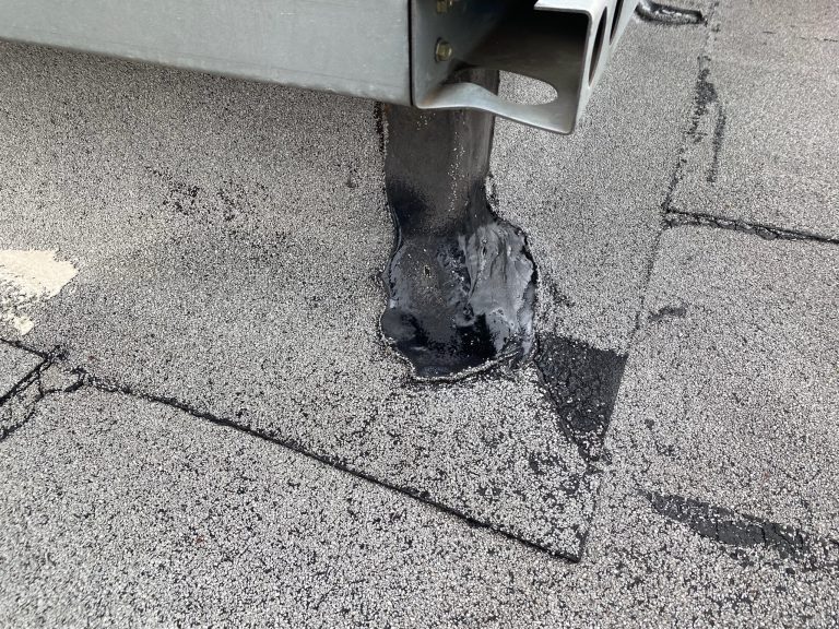 roof bros restoration illinois roof repair 001 - Roof Bros Restoration - roofing gallery wisconsin illinois A close-up of a flat roof showing a metal support post with black sealant applied around its base on the membrane surface