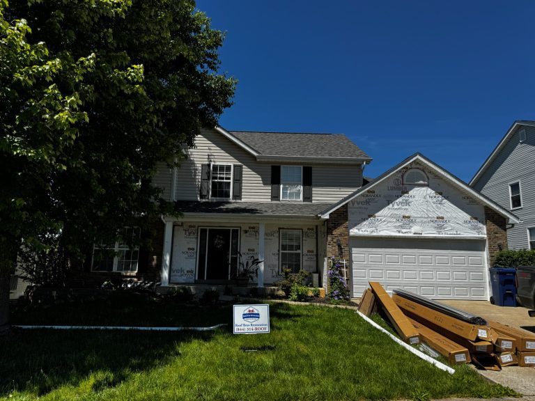 roof bros restoration illinois siding install 001 - Roof Bros Restoration - roofing gallery wisconsin illinois A two-story home in mid-renovation shows exposed house wrap on the gables with stacked construction materials in the drive...