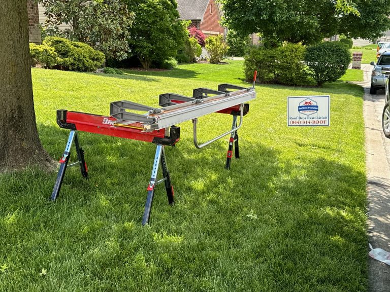 roof bros restoration jobsite 002 - Roof Bros Restoration - roofing gallery wisconsin illinois A red metal sheet-metal brake set up on sawhorses on a residential front lawn with a Roof Bros Restoration yard sign next...