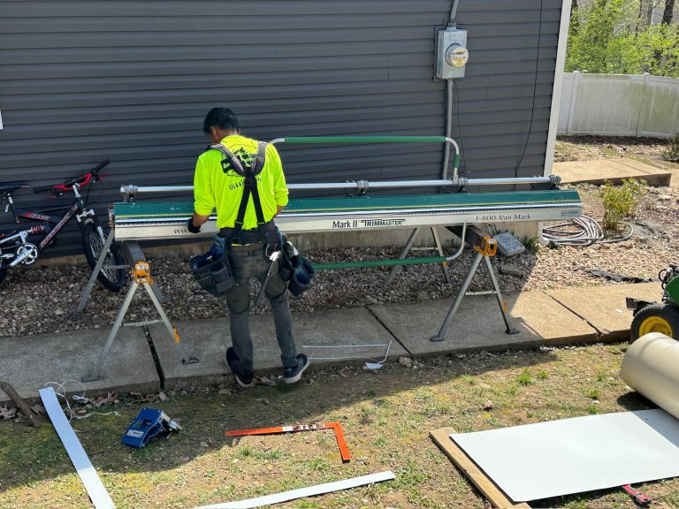 roof bros restoration jobsite 009 2 - Roof Bros Restoration - roofing gallery wisconsin illinois A worker in a high-visibility yellow shirt and harness operates a Tapco Mark II Van Mark sheet-metal brake set on sawhorse...