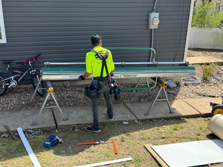 roof bros restoration jobsite 010 - Roof Bros Restoration - roofing gallery wisconsin illinois A worker in a high-visibility yellow shirt and harness stands at a Tapco Mark II Van Mark sheet-metal brake set up on sawh...