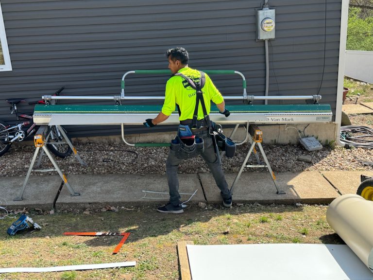 roof bros restoration jobsite 011 - Roof Bros Restoration - roofing gallery wisconsin illinois A worker in a high-visibility yellow shirt and harness carries trim material past a Van Mark sheet-metal brake set on sawh...