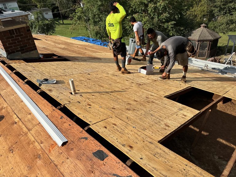 roof bros restoration roof install 003 - Roof Bros Restoration - roofing gallery wisconsin illinois Four workers stand on a residential roof with the plywood decking exposed and a chimney visible during tear-off and re-dec...