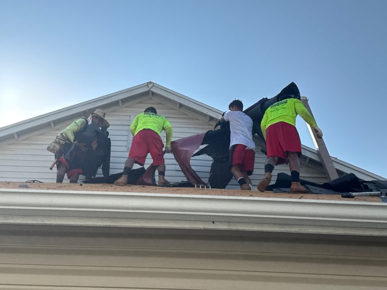 roof bros restoration roof install 004 - Roof Bros Restoration - roofing gallery wisconsin illinois Four workers standing on a residential roof tearing off old black shingles and underlayment near the gable end of a house...