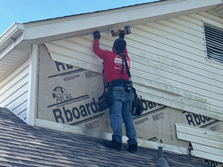 roof bros restoration siding install 004 - Roof Bros Restoration - roofing gallery wisconsin illinois A worker in a red shirt stands on a shingled roof using a nail gun to install siding panels over Atlas Rboard sheathing on...