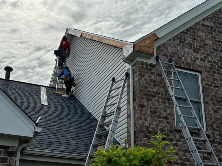 roof bros restoration siding install 008 - Roof Bros Restoration - roofing gallery wisconsin illinois Two workers stand on ladders against a two-story home replacing siding and trim near a roofline gable