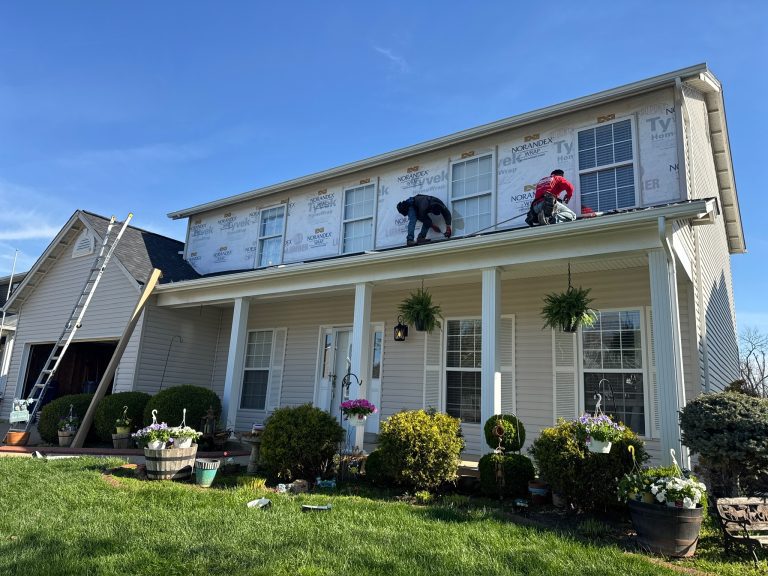roof bros restoration siding install 014 - Roof Bros Restoration - roofing gallery wisconsin illinois Two workers on a two-story residential home installing Norandex weather-resistant barrier wrap on the upper-story exterior...