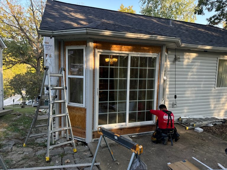 roof bros restoration siding install 016 - Roof Bros Restoration - roofing gallery wisconsin illinois A residential home with a sunroom or enclosed porch addition under construction, showing a sliding glass door, exposed ply...
