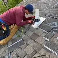 Roof Replacement in St. Louis, MO — Close Up of a Roofer Close-up of a roofer installing pipe-boot flashing around a plumbing vent on a new shingle roof — St. Louis, MO