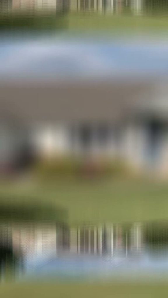 roof bros restoration video poster madison wi roofing 001 - Roof Bros Restoration - roofing gallery wisconsin illinois Heavily blurred and mirrored frame showing what appears to be a single-story house with green lawn and sky, no sharp detai...