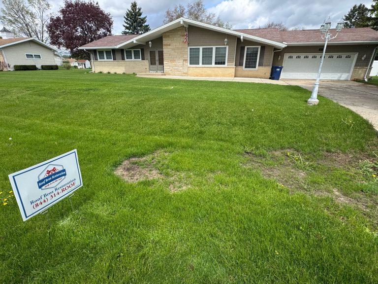 roof bros restoration wisconsin yard sign 001 2 - Roof Bros Restoration - roofing gallery wisconsin illinois A Roof Bros Restoration yard sign placed on a green lawn in front of a single-story tan brick ranch-style home with an att...