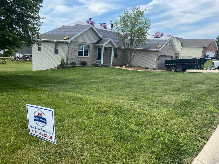roof bros restoration yard sign 001 - Roof Bros Restoration - roofing gallery wisconsin illinois A wide front-yard view of a one-story brick and tan-siding home with a roof tear-off in progress, two workers visible on t...